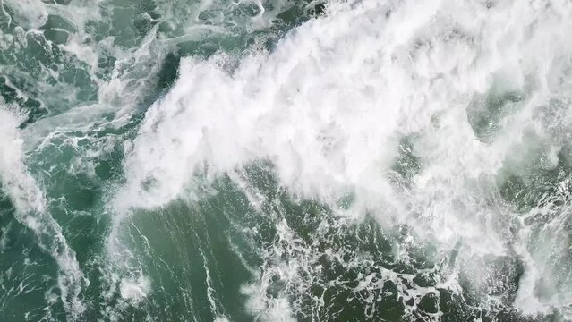 Sea waves and a rock. View on the rough ocean water from the top.