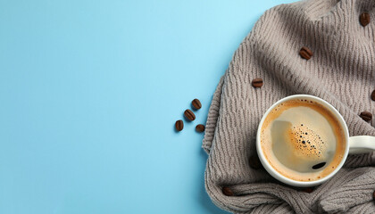 Flat lay composition with coffee and warm plaid on light blue background, space for text