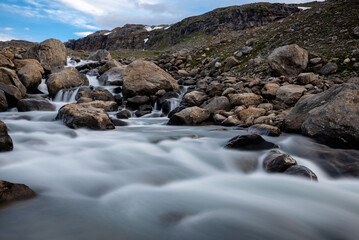 Long exposure of Mørkbekken going through Okstindan mountain range, Hemnes, Helgeland, Norway. Nordland bäck. Fast flowing mountain water. Foss genom Okstindan. Rabothytta waterfall. Rocky landscape