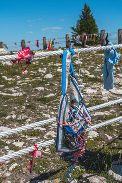 At the roped-off  Native American Indian medicine wheel on the top of a mountain in Montana you see cloth mementos, remembrances, & gifts tied to the rail line.