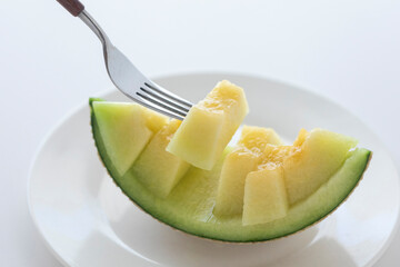 フォークで持ち上げるメロン
