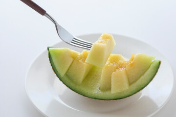 カットしたメロンをフォークで持ち上げる