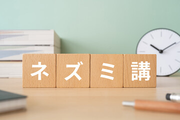 ネズミ講と書かれたブロックが置かれたデスク