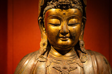 Fototapeta na wymiar Statue of the buddha over the red background