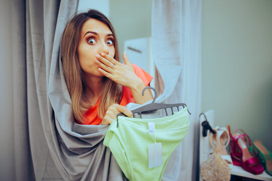 Funny Woman Trying on panties in a Changing Room. Embarrassed girl feeling self-conscious after trying on a bathing suit 
