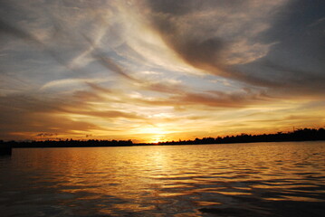 Fototapeta premium Scenic view dramatic beautiful sunset sky. Natural Sunset Sunrise on meadow silhouette shadow dark land. Vibrant dramatic sky on sunset, dawn, sunrise in Countryside. Landscape Colorful Sky At Sunset