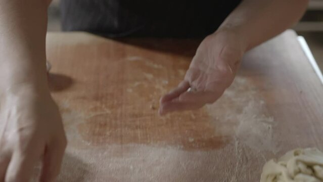 Baking traditional Sardinian Panadas rolling dough with hands close