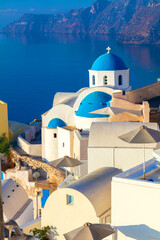 Fototapeta premium Greece, Santorini. White architecture and blue domes of Santorini against the backdrop of the sea.