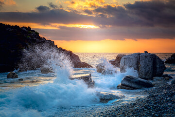Seascape. Sea Ocean Wave hit the rock at beach, sea water splash up to the sky with sun. Sunset Sundown at Sea. Storm. Seascape.