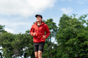 Attractive Young indian man wearing sportswear running on track at sport stadium. Asian Fit man jogging outdoor cross the finish line. Exercise in the morning. Healthy and active lifestyle concept.