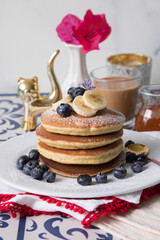 Pancakes stack with banana and blueberries topping and bee honey breakfast food