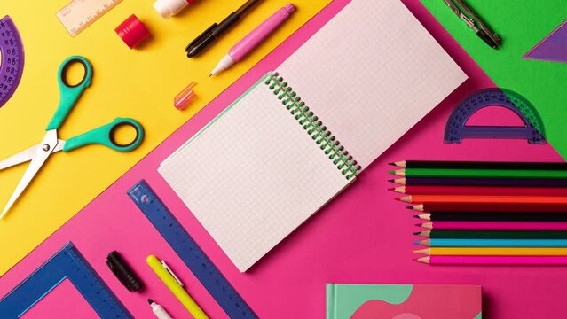 Stopmotion animation of composition of multi-colored stationery items laid out on the table. office, school FLAT LAY pink, yellow, green background. Copy space notebook. 4k footage, video, motion, spl