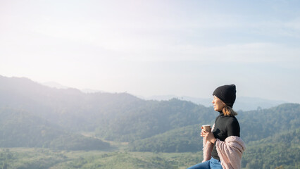 woman traveler drinks coffee with view of mountain landscape. young tourist woman drinks hot drink from cup and enjoyed the scenery in mountains. trekking concept. concept adventure active vacations.