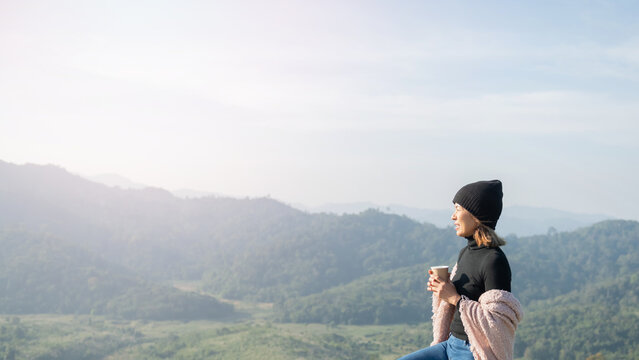 woman traveler drinks coffee with view of mountain landscape. young tourist woman drinks hot drink from cup and enjoyed the scenery in mountains. trekking concept. concept adventure active vacations.
