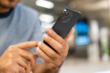 Young man holding using smartphone on urban city background.