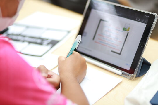 Smart young man reading documents while editing electronic versions on smartphone and laptop apps. Male freelancer working with documents and using technology
