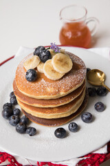 Pancakes stack with banana and blueberries topping and bee honey breakfast food