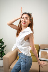 Young trendy influencer asian woman dancing posing on camera at home in living room. Creator...