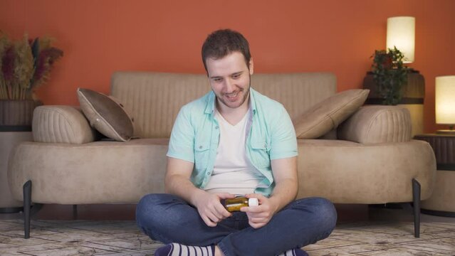 The man who looks at the pills in his hand and is going to commit suicide.