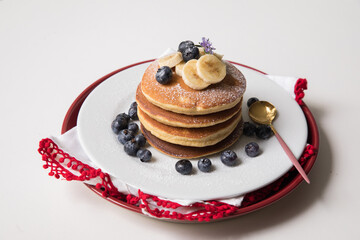 Pancake stack with banana and blueberries topping and bee honey breakfast food