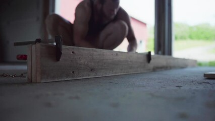 Carpenter Using Clamps On Wooden Plank In Workshop. Close Up