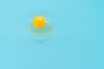 Directly above view of raw egg yolk against turquoise background 