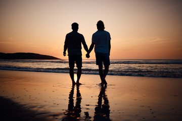 Silhouette, holding hands and gay men on beach, sunset and shadow on summer vacation together in...