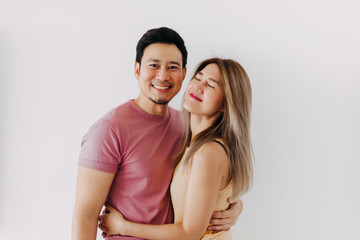 Happy asian Thai couple smiling look at each other, cuddle and hugging with love, new marriage life, isolate over white background.
