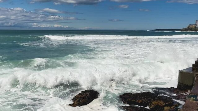HD Video-Waves crashing on the sea wall at North Cronulla Beach in Sydney, Australia. Due to coastal erosion and following a severe storm in June 2022, a huge amount of sand was ripped from the beach.