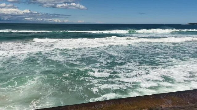 HD Video-Waves crashing on the sea wall at North Cronulla Beach in Sydney, Australia. Due to coastal erosion and following a severe storm in June 2022, a huge amount of sand was ripped from the beach.