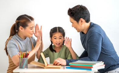 Portrait  happy love asian family father and mother with little asian girl learn and study on table.Mom and dad with asian young girl writing with book make homework in homeschool at home.Education