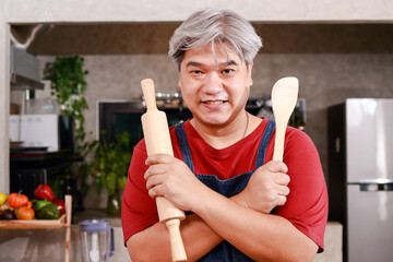 Portrait of a fat Asian male chef cooking food in the kitchen at home. food concept