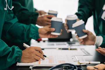 Medical team,  holds a cup of coffee and smiles happily. working together as a team at the hospital..