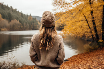 Person enjoying a morning walk by the river in a cozy sweater 
