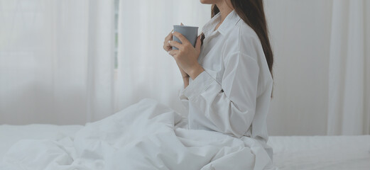 Happy freelance asian woman work on tablet on the hotel bed on travel trip.