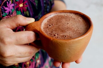 Frothy Guatemalan traditional hot chocolate in a clay cup