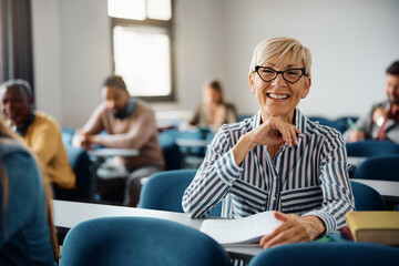 Happy mature woman attending adult education training course and looking at camera.