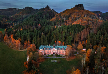 Jetrichovice, Czech Republic - Aerial view of beautiful mansion near Jetrichovice at sunset on an autumn day with Mariina vyhlidka viewpoint at background. Autumn landscape in Bohemian Switzerland