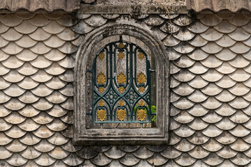 Old house wall with a badass concrete fish-scale design. Vintage window. Wall covered in lush moss. Harsh lighting, vibrant contrasting shadows © Маргарита Трушина