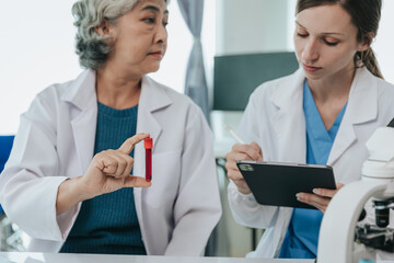 Scientists are doing research in a medical laboratory. Foreground researcher using a microscope