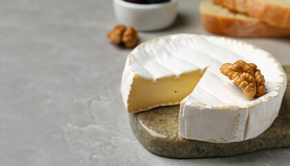 Tasty brie cheese on light table, closeup. Banner design with space for text