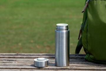 夏の晴れた日のベンチに置かれた水筒とリュックサック