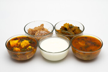 Indian home made food thali with matar paneer, halwa, pumpkin gravy, curd, yogut and potato gravy