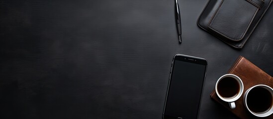 modern workplace in a company, featuring a cellphone, espresso, leather planner, and pen, all set on a black backdrop with blank space.