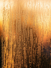 Drops of water on the window glass at sunrise. Background