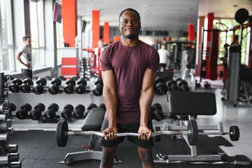 Naklejka na ściany i meble Young athletic African American man in the gym