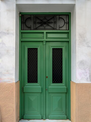 A classic design house entrance with a green painted wooden door. Travel to Athens, Greece.