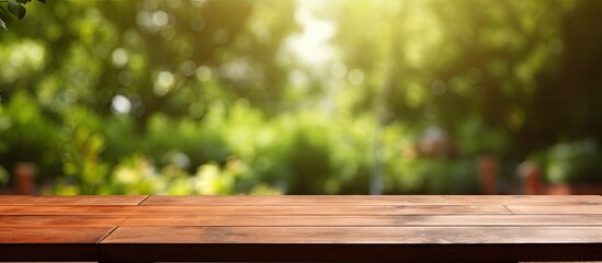 An empty wooden table is placed outdoors in a garden, with a blurred background. The table is clean and offers ample space for text, making it suitable for marketing and promotional purposes. It