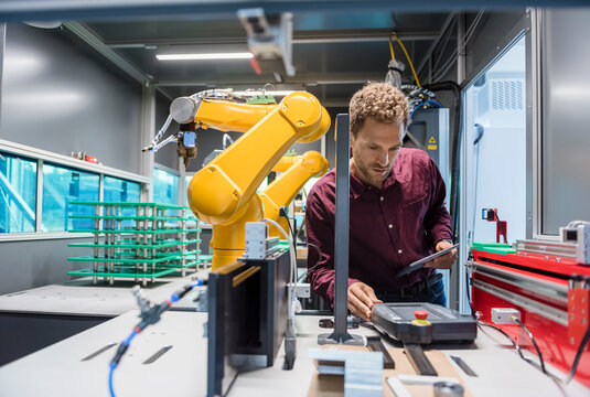 Businessman checking industrial robot in high tech company