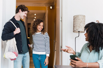 Mother greeting father and daughter coming from shopping groceries